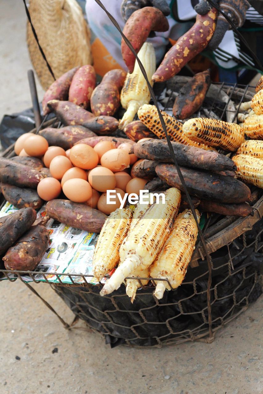 High angle view of corn and sweet potatoes with eggs at street market