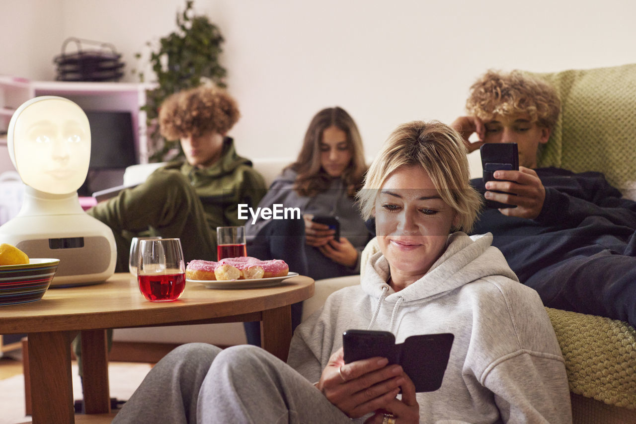 Mother with children using electronic devices at home