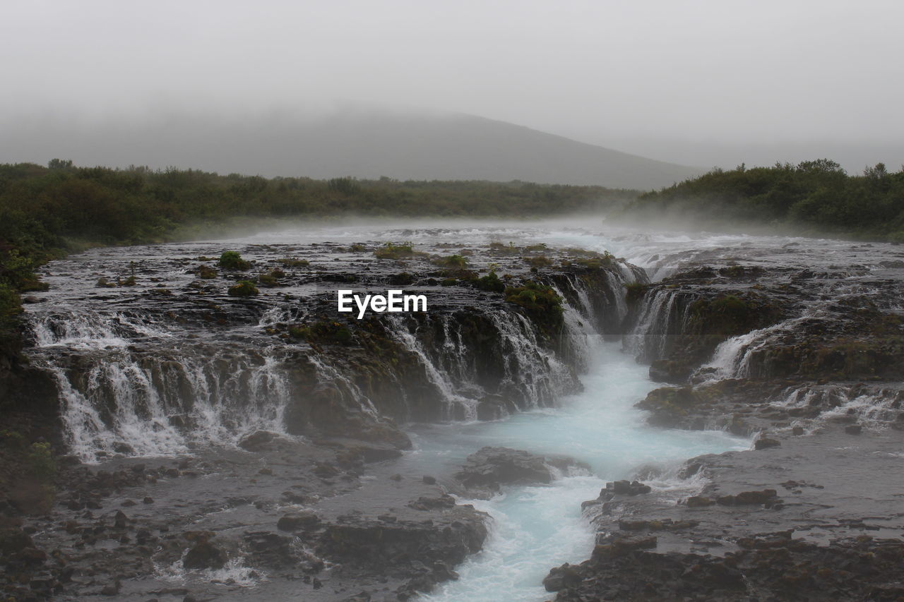 VIEW OF WATERFALL AGAINST SKY