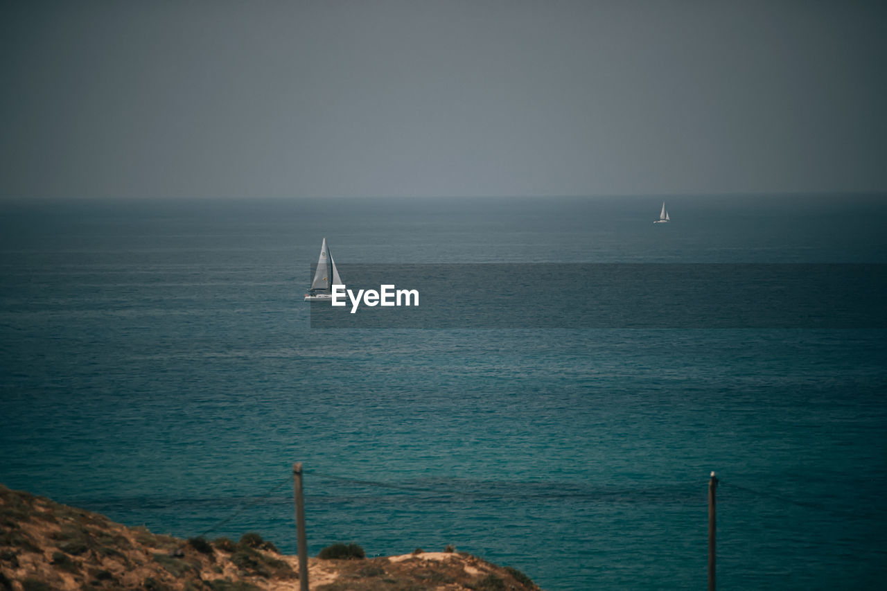 Sailboat sailing on sea against sky