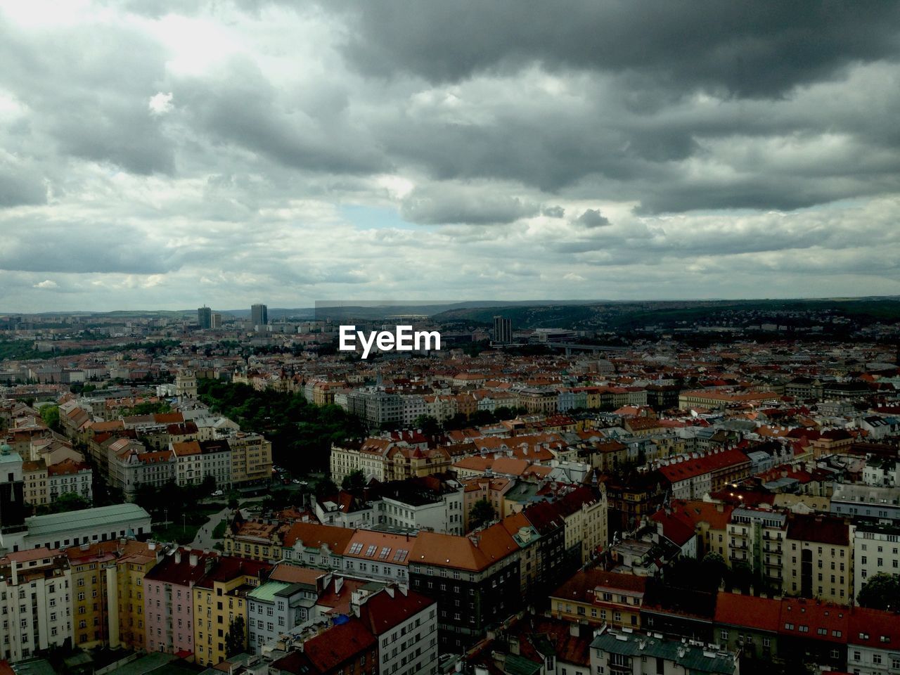 High angle shot of cityscape against clouds