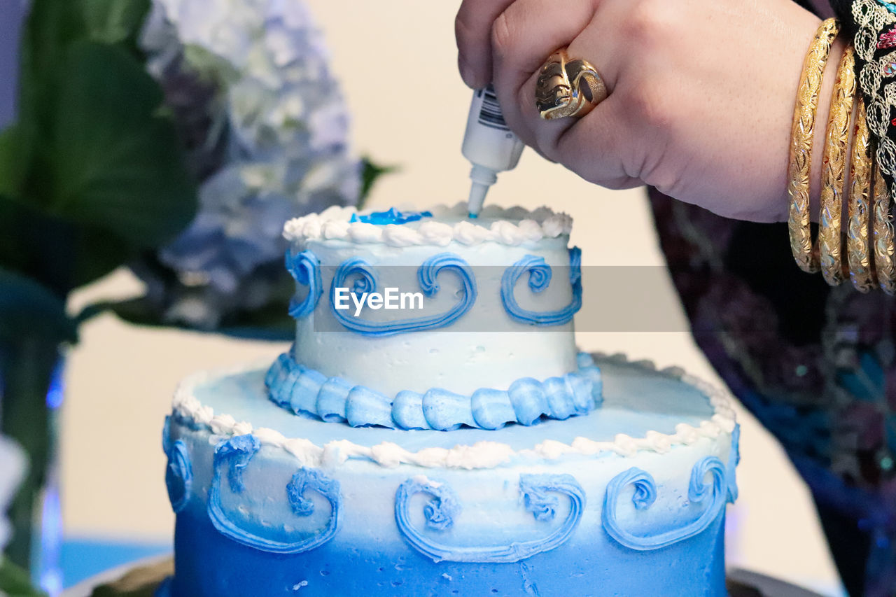 Cropped image of woman decorating cake