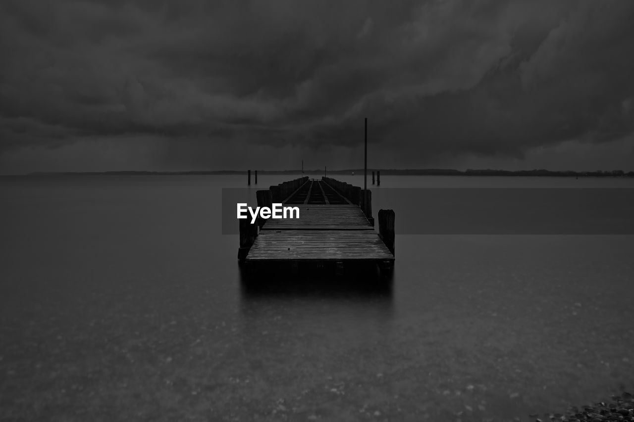 Boat on sea against storm clouds