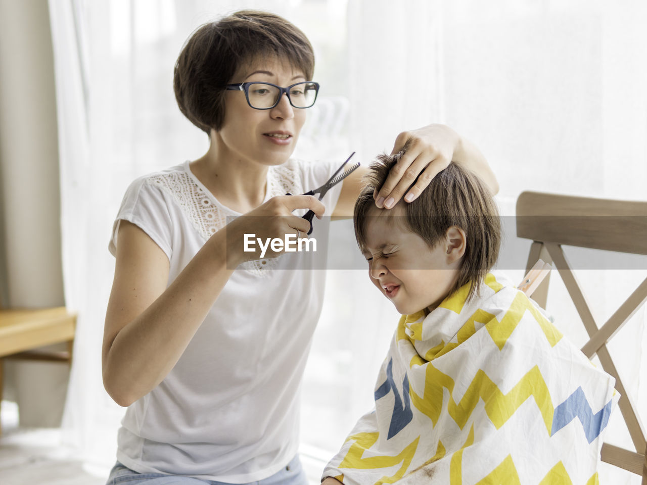 Mother trimming sons hair at home