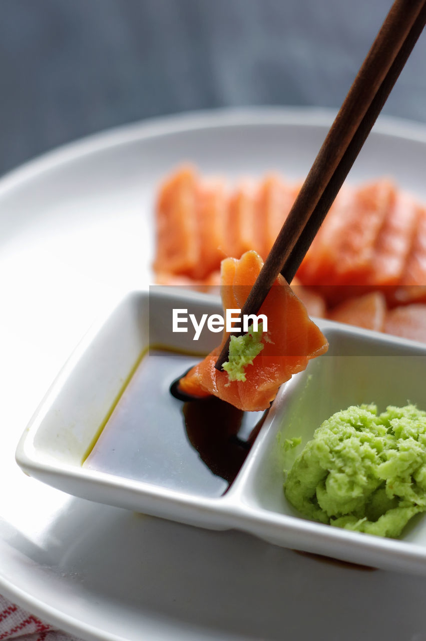 Close-up of salmon wasabi dipped in soy sauce