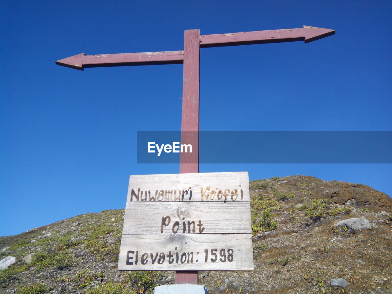 Low angle view of a road sign against a blue sky on the tricolor lake of kelimutu, ende, indonesia