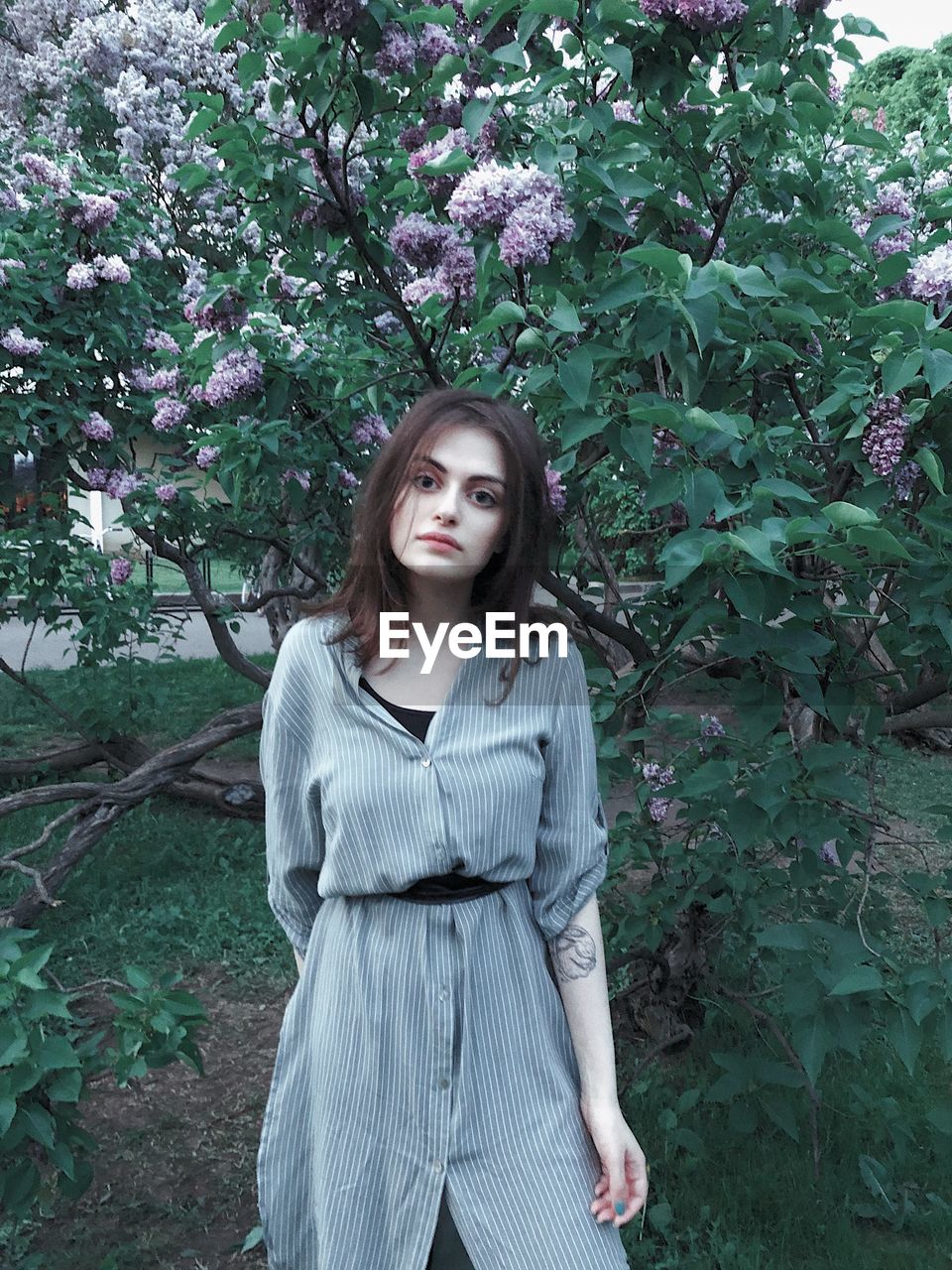 Portrait of young woman standing against plants