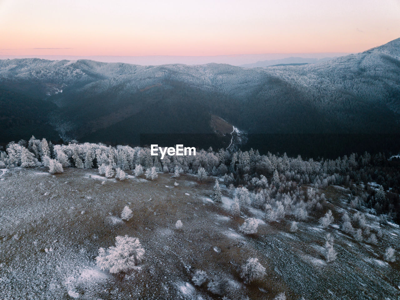 Scenic view of snowcapped mountains against sky during sunset