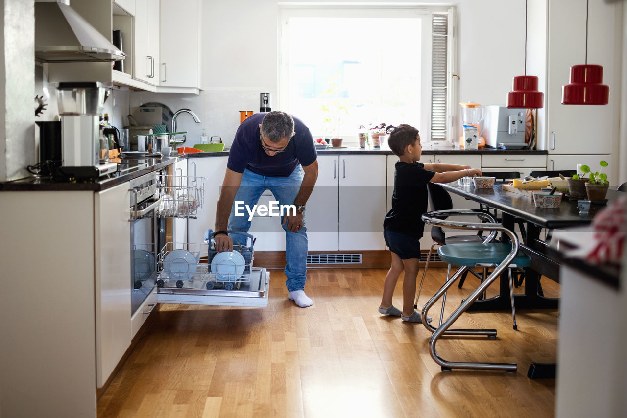 Father and son working in kitchen at home