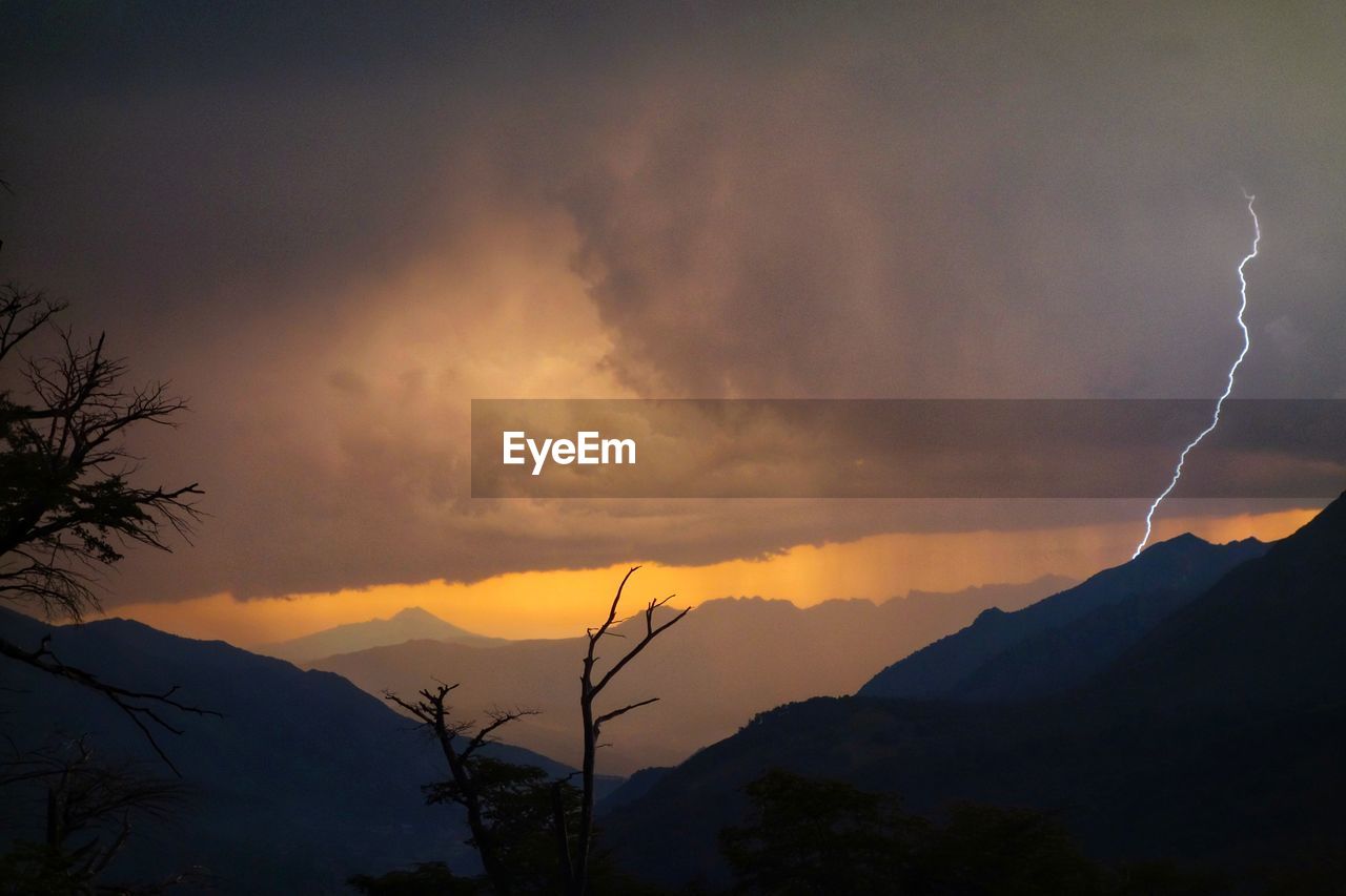 Silhouette of mountain against dramatic sky during sunset