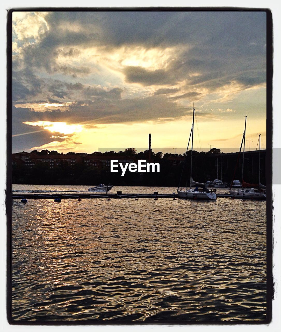 BOATS IN SEA AT SUNSET