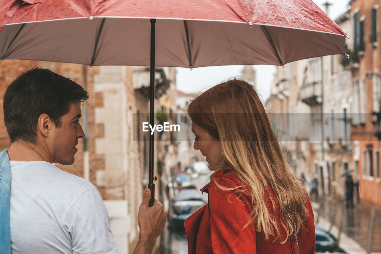 SIDE VIEW OF A WOMAN WITH UMBRELLA