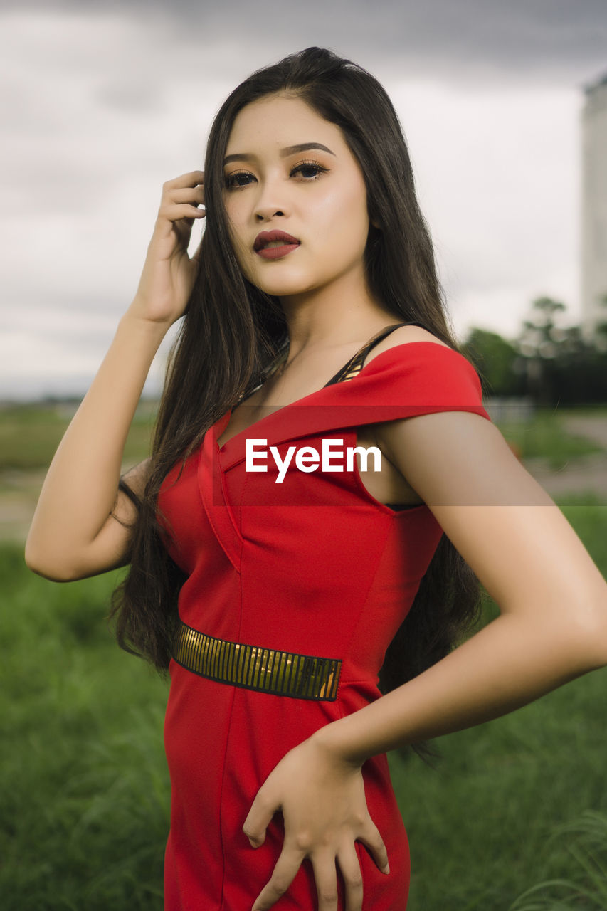 BEAUTIFUL YOUNG WOMAN STANDING IN A FIELD