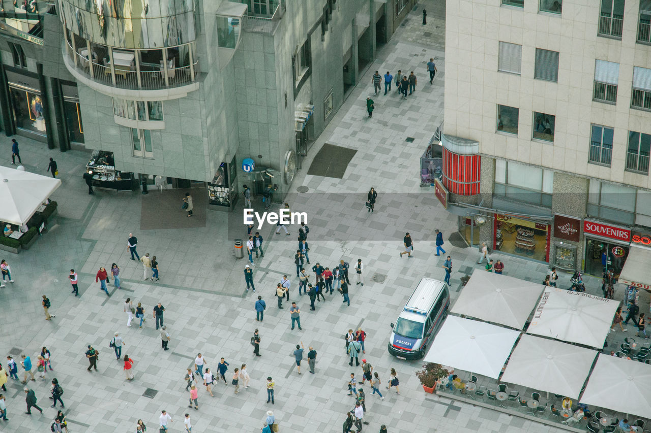 HIGH ANGLE VIEW OF PEOPLE WALKING ON ROAD