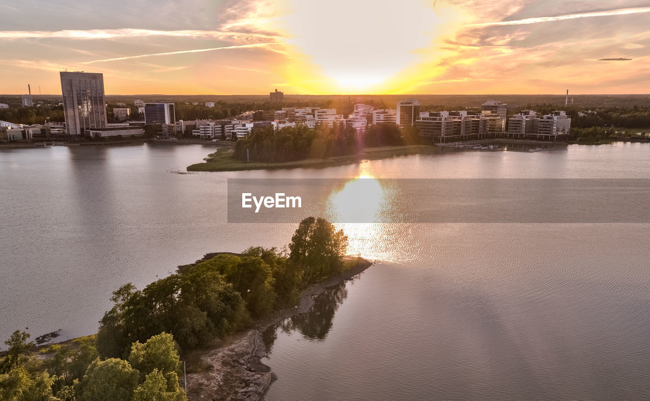 SCENIC VIEW OF RIVER AGAINST SKY DURING SUNSET IN CITY