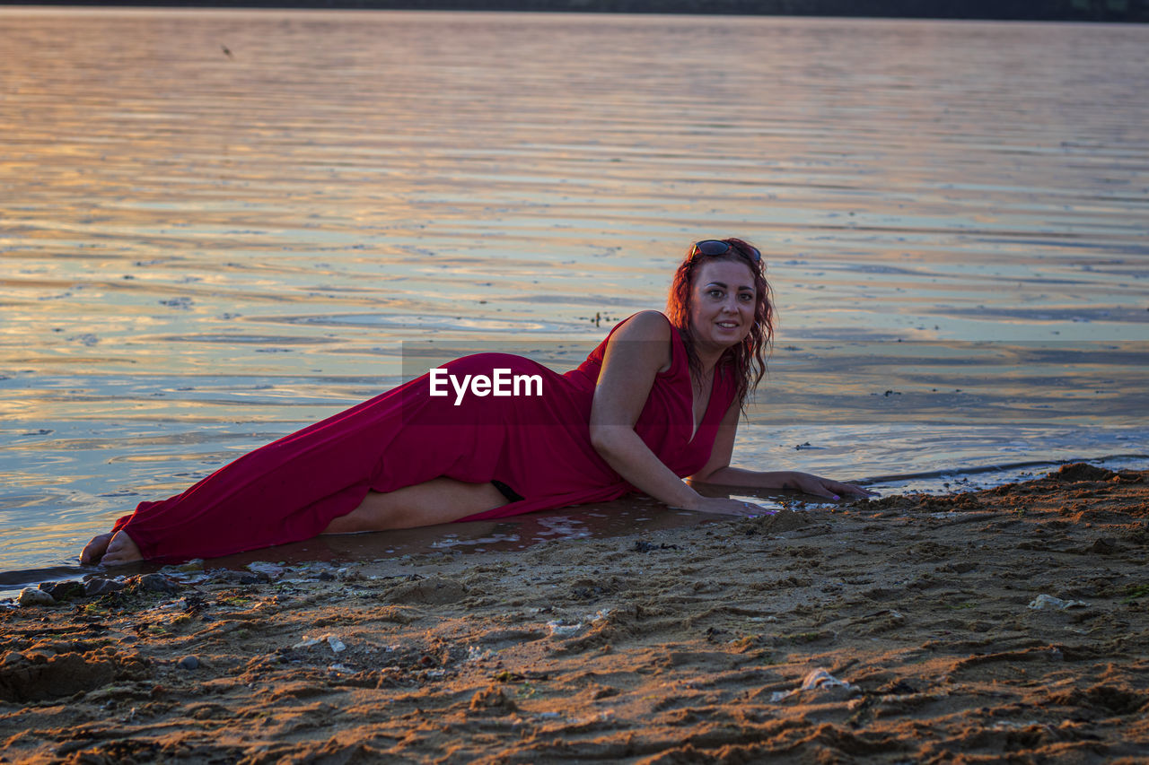 PORTRAIT OF YOUNG WOMAN IN WATER AT BEACH