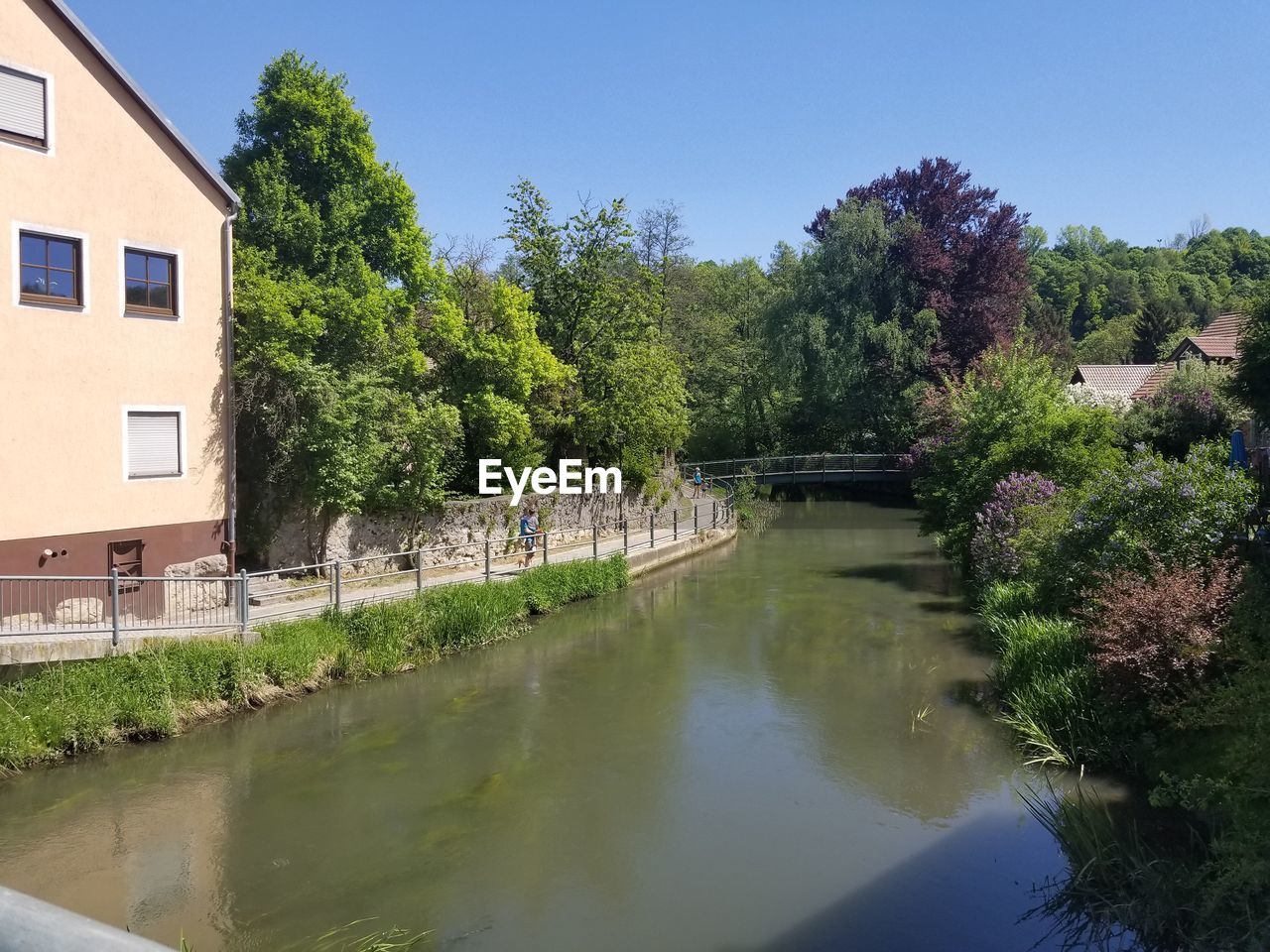 SCENIC VIEW OF RIVER BY TREES AND BUILDINGS AGAINST SKY