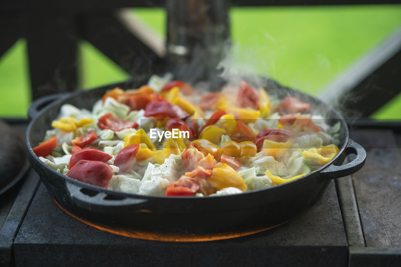 A stew made of red peppers, potatoes, beef, cabbage and other vegetables in a cast-iron cauldron