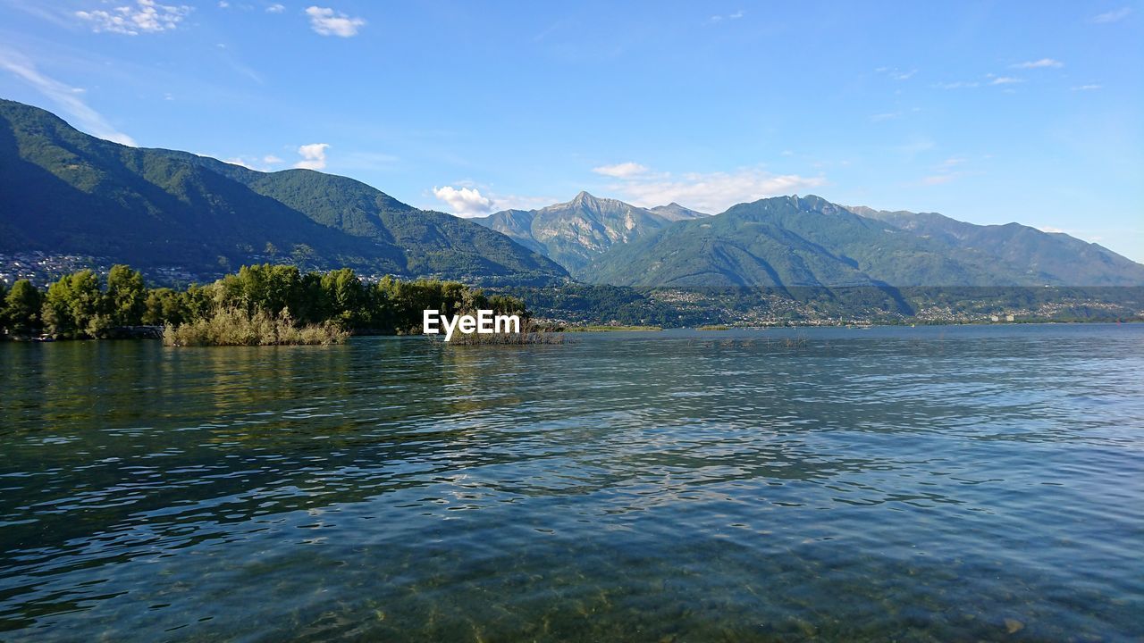 Scenic view of lake by mountains against sky