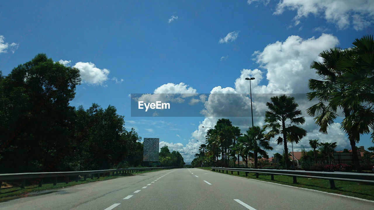 Road amidst trees against sky