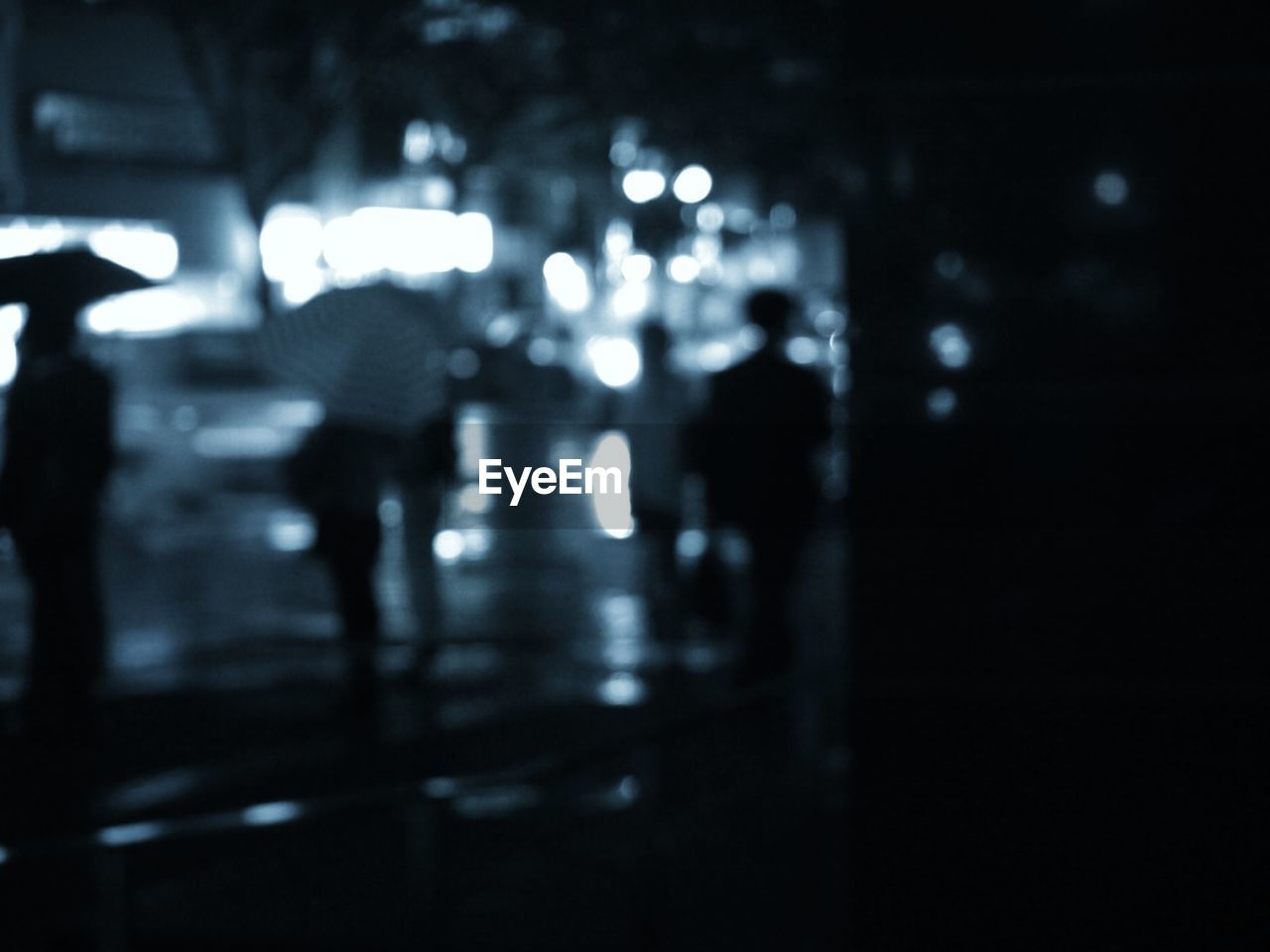 Blurred image of silhouette people walking on street