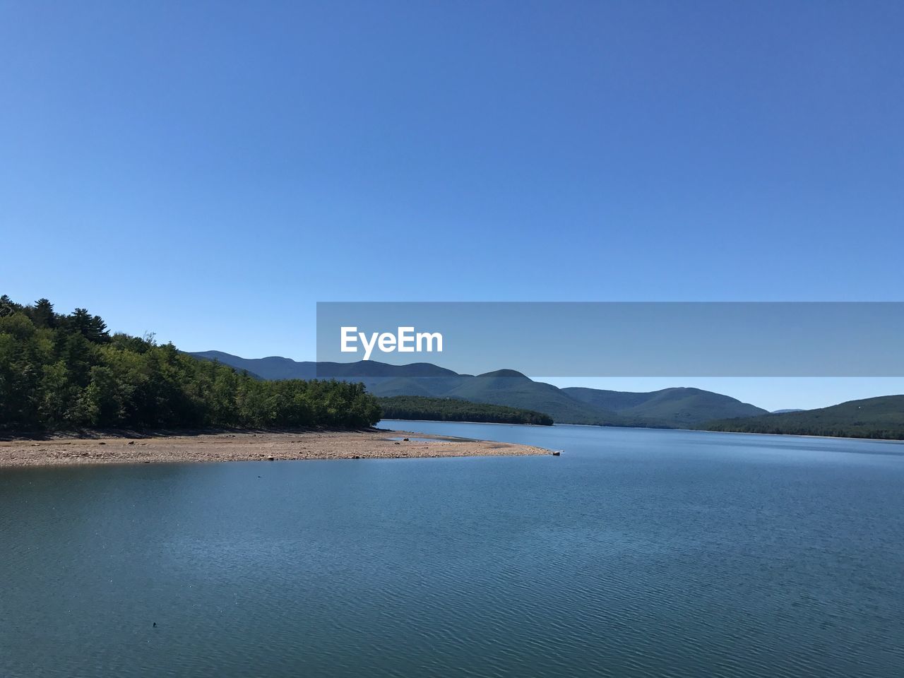 Scenic view of lake against clear blue sky