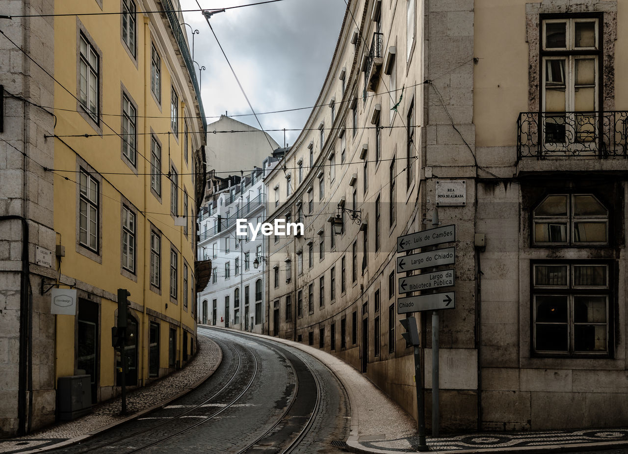 A slightly ascending road runs between the large houses of an old town