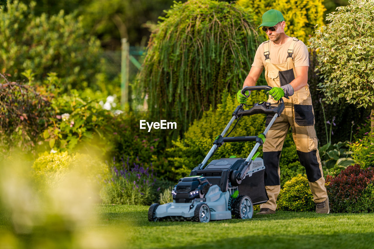 Full length of gardener gardening at yard