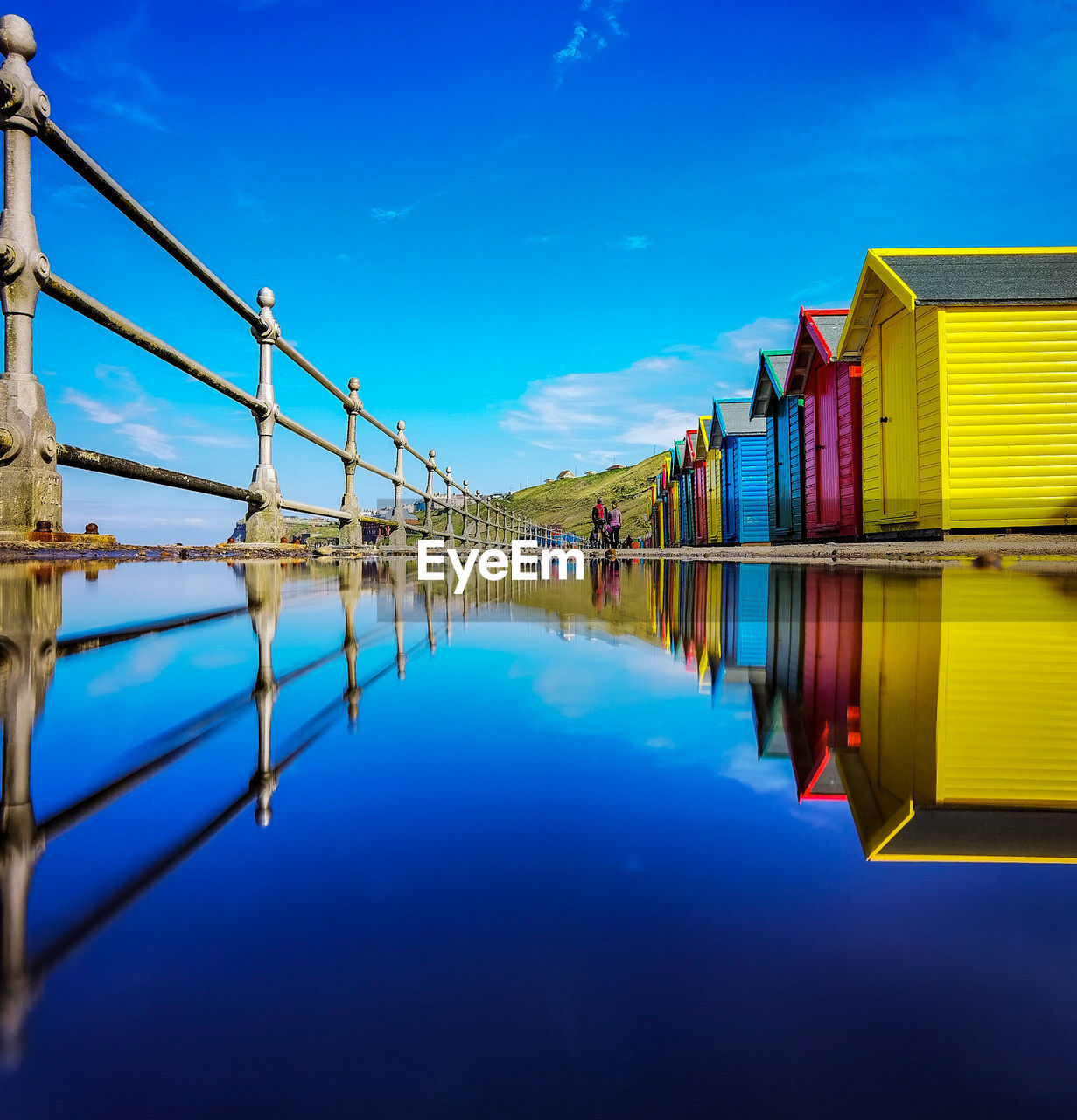 Scenic view of lake and buildings against blue sky