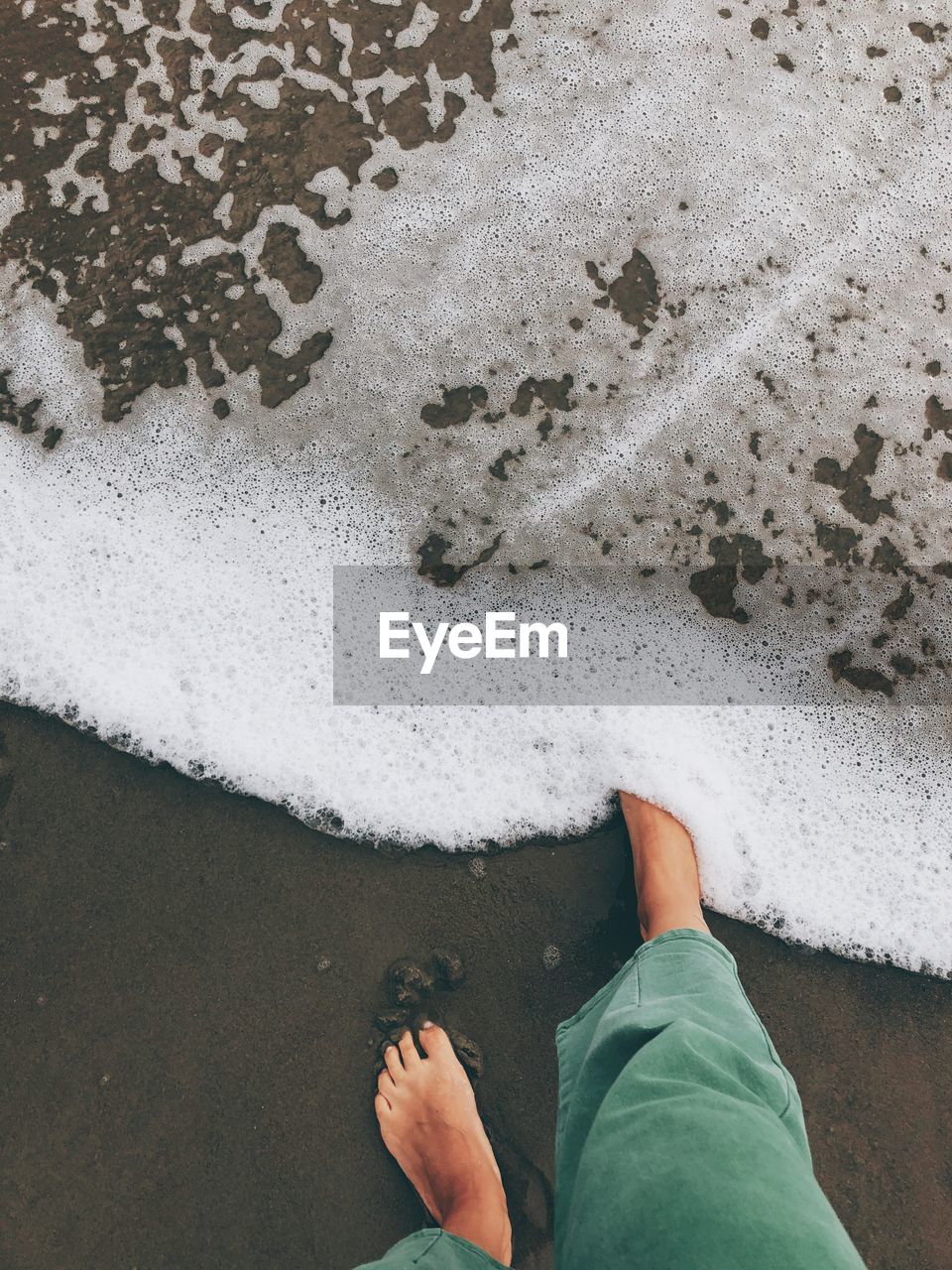 Low section of woman standing on beach