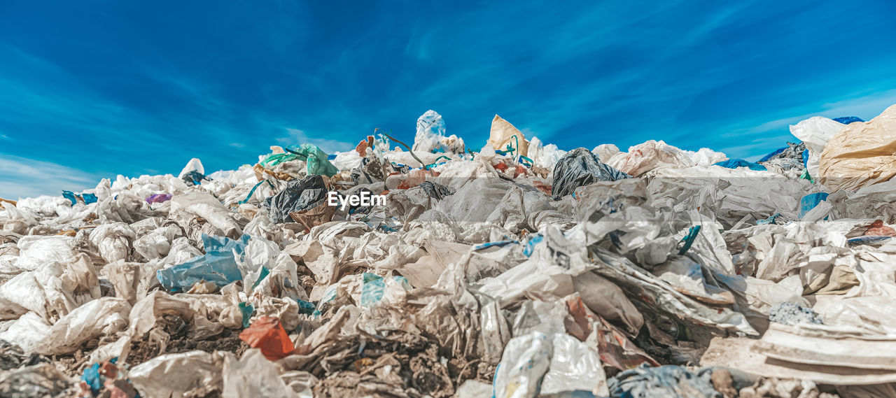 LOW ANGLE VIEW OF GARBAGE AT BLUE SEA AGAINST SKY