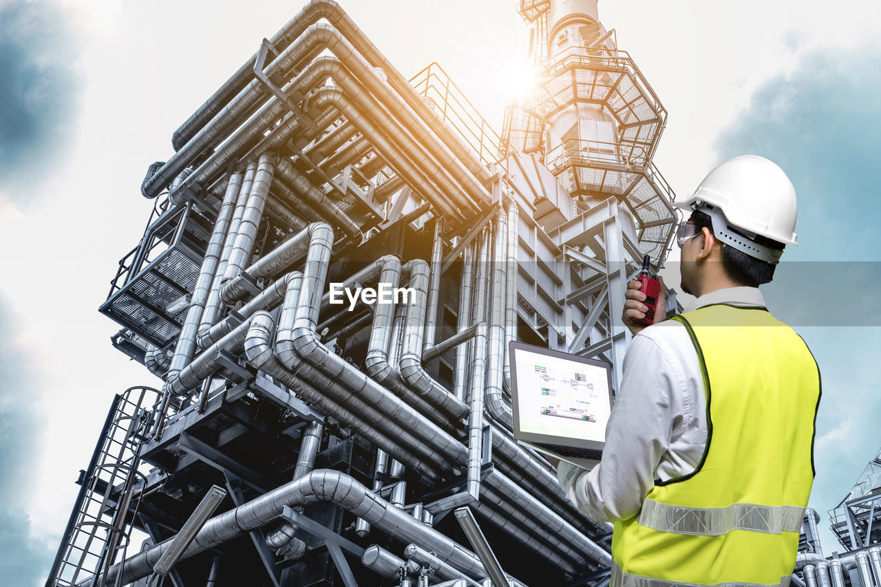 LOW ANGLE VIEW OF MAN WORKING AT CONSTRUCTION SITE