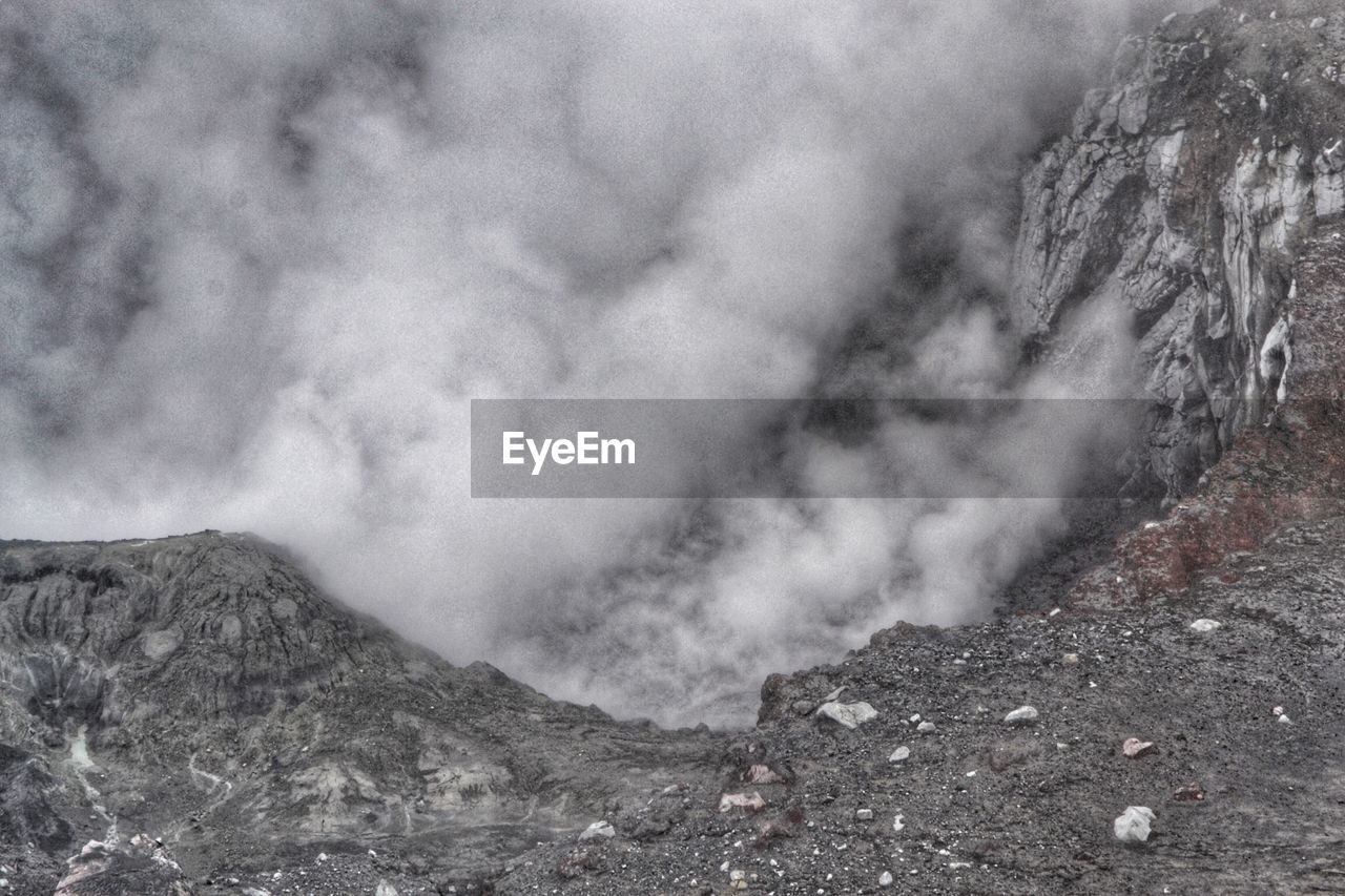 Smoke emitting from volcanic mountain against sky