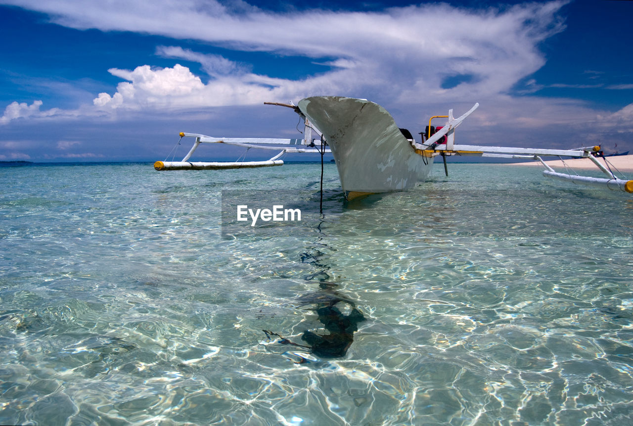 Clear tranquil water and traditional boat on kokoya island, morotai, north maluku, indonesia