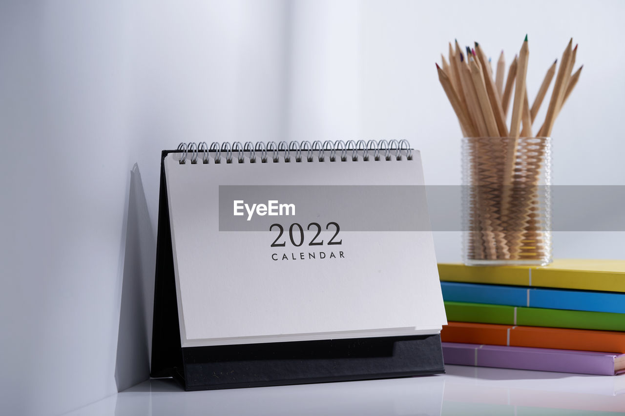 Calendar 2022 and color pencils in the plastic holder