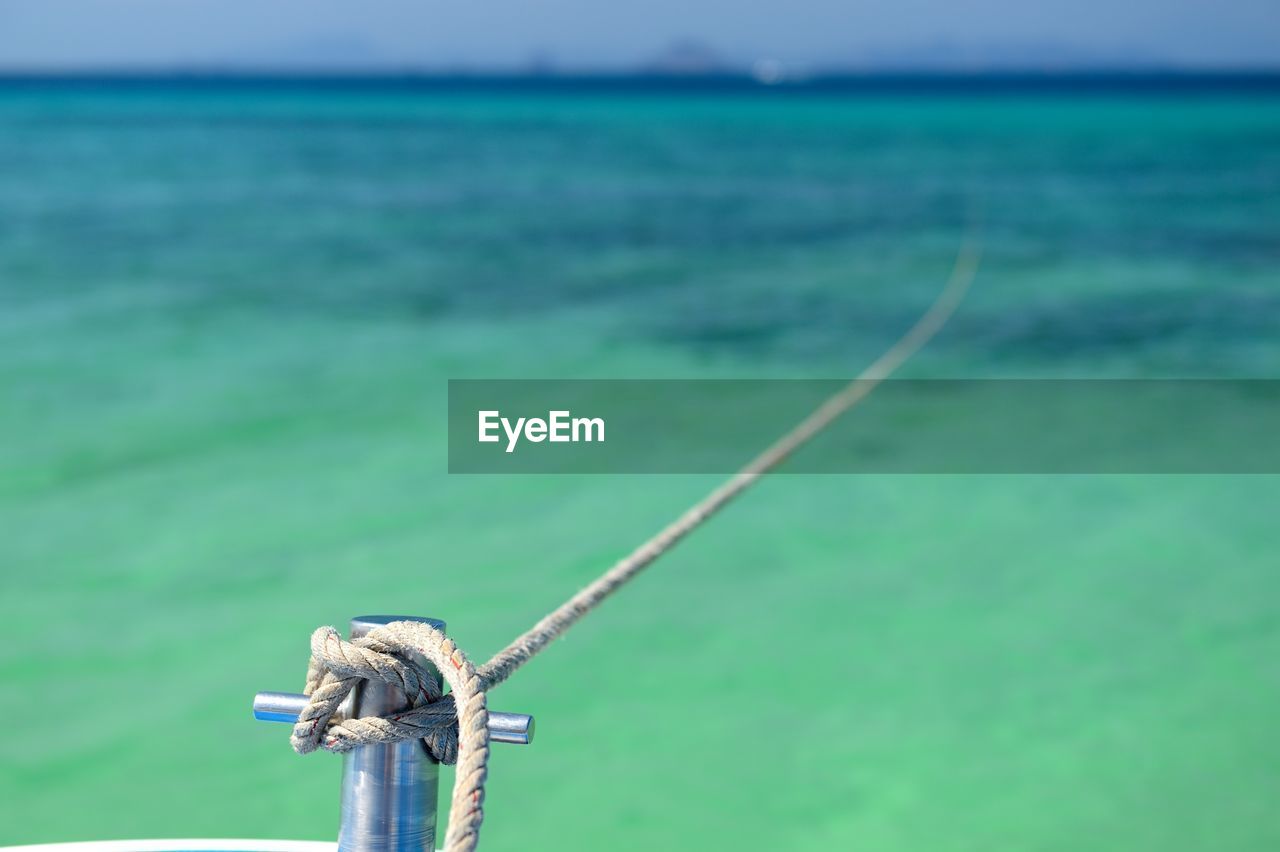 CLOSE-UP OF ROPE TIED TO FISHING NET