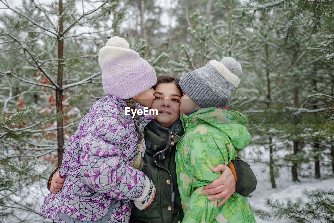 rear view of woman wearing hat standing in forest during winter