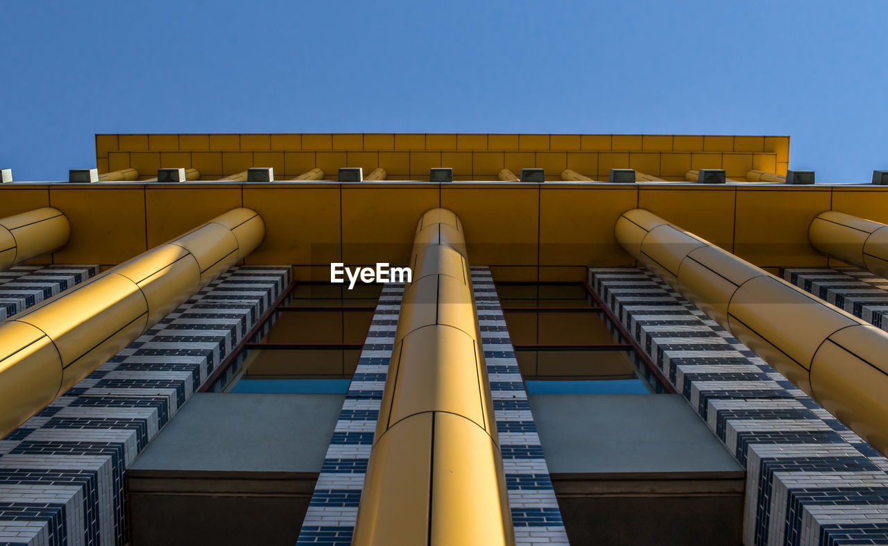 LOW ANGLE VIEW OF MODERN BUILDING AGAINST BLUE SKY