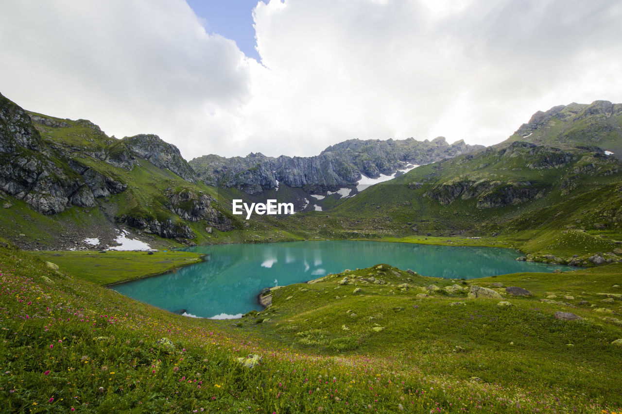 Alpine mountain lake landscape and view, blue beautiful and amazing lake panorama, wide angle.