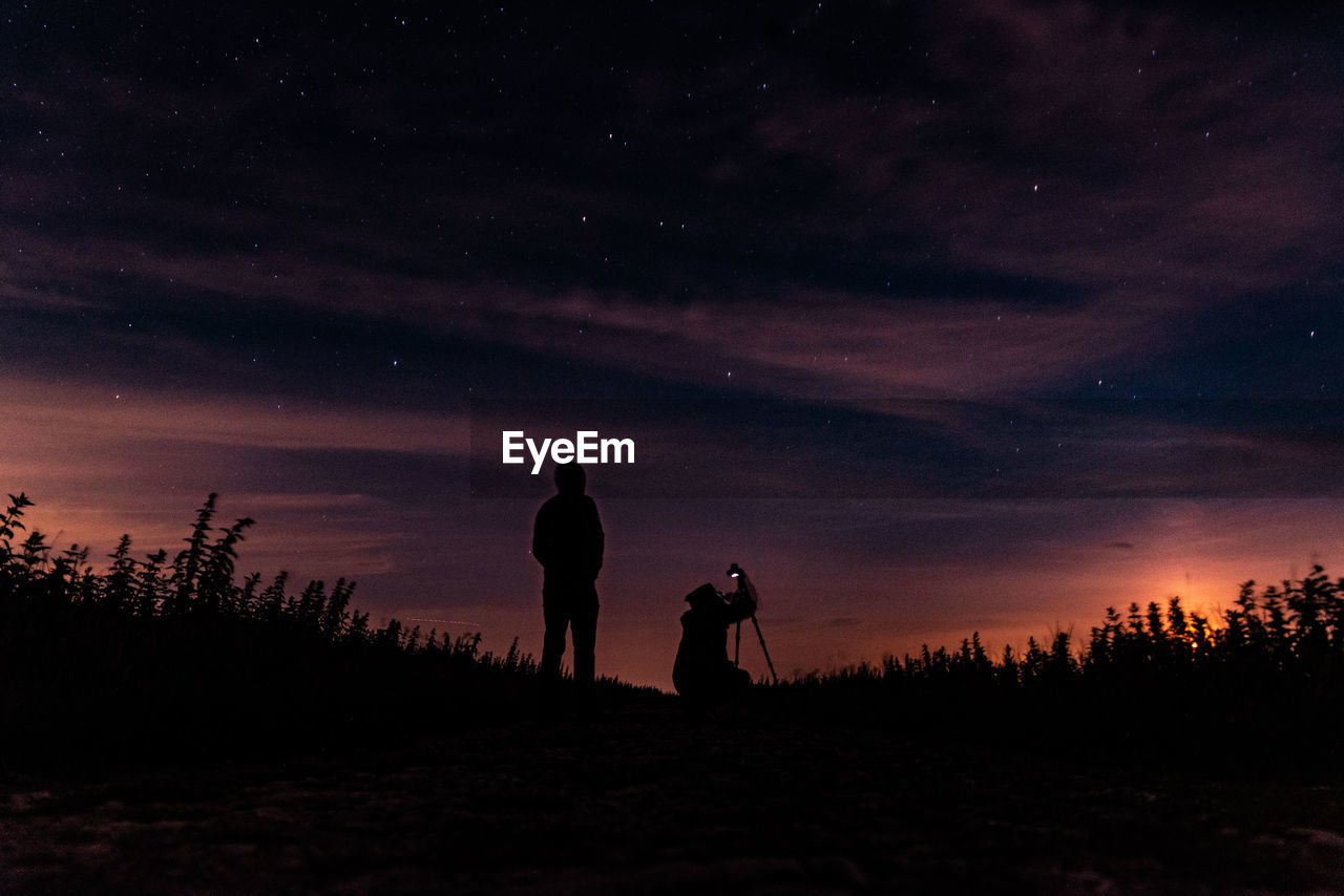 SILHOUETTE PEOPLE ON FIELD AGAINST SKY AT NIGHT