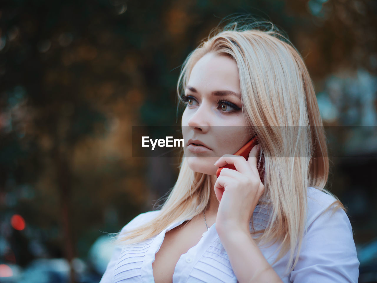 Young woman talking on mobile phone while sitting at bench