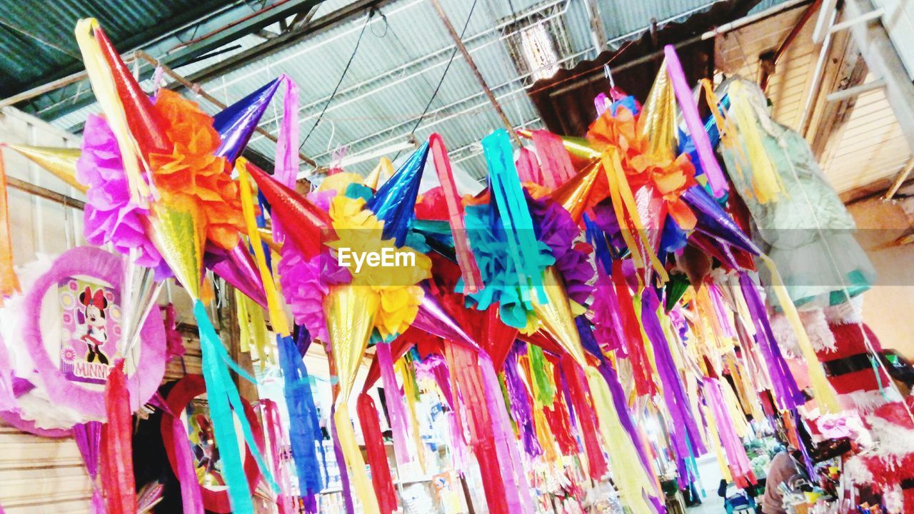 CLOSE-UP OF MULTI COLORED UMBRELLAS HANGING ON WALL