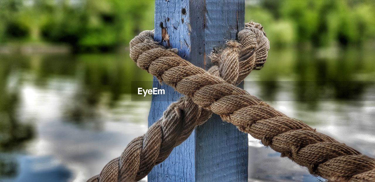 CLOSE-UP OF ROPES TIED ON WOODEN POST