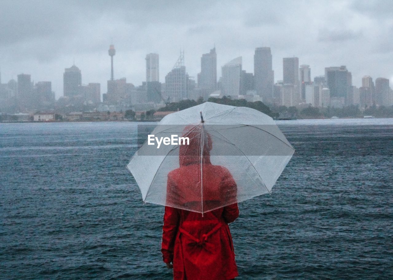 Person with umbrella standing in rain during rainy season