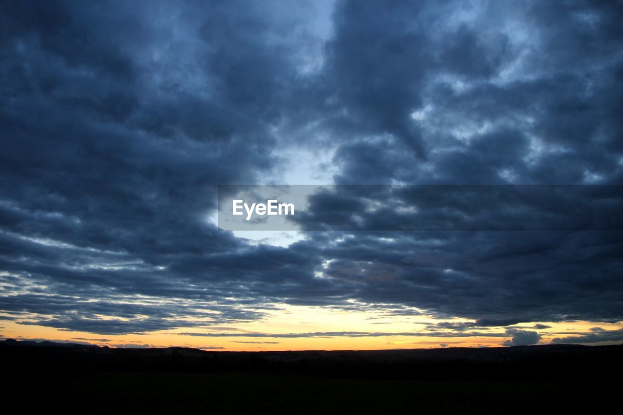 SILHOUETTE LANDSCAPE AGAINST CLOUDY SKY DURING SUNSET