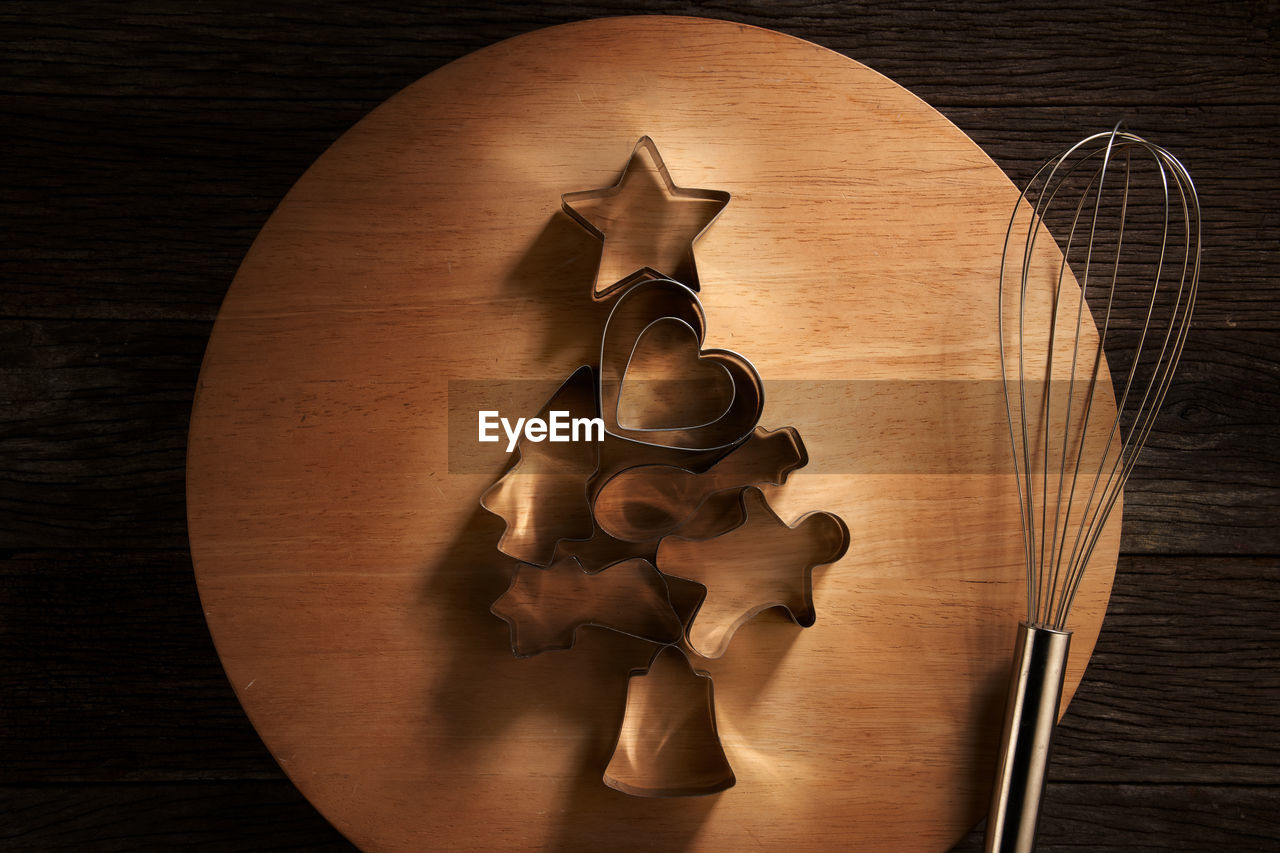 Top view of christmas cookies cutter arranged to a christmas tree shape on wooden table