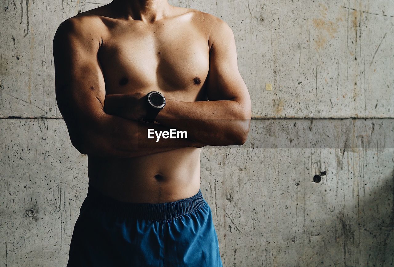 Midsection of shirtless man in gym