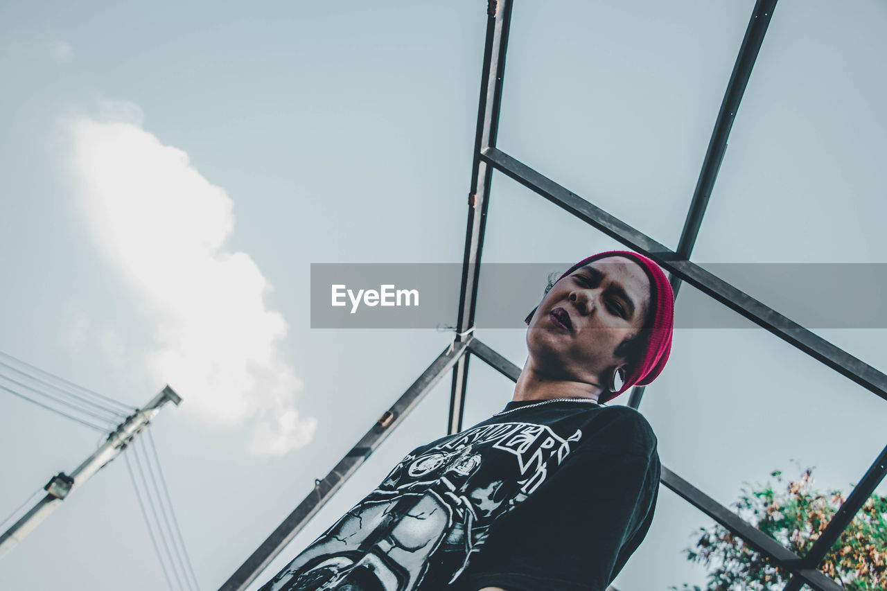 Low angle view portrait of young man against sky