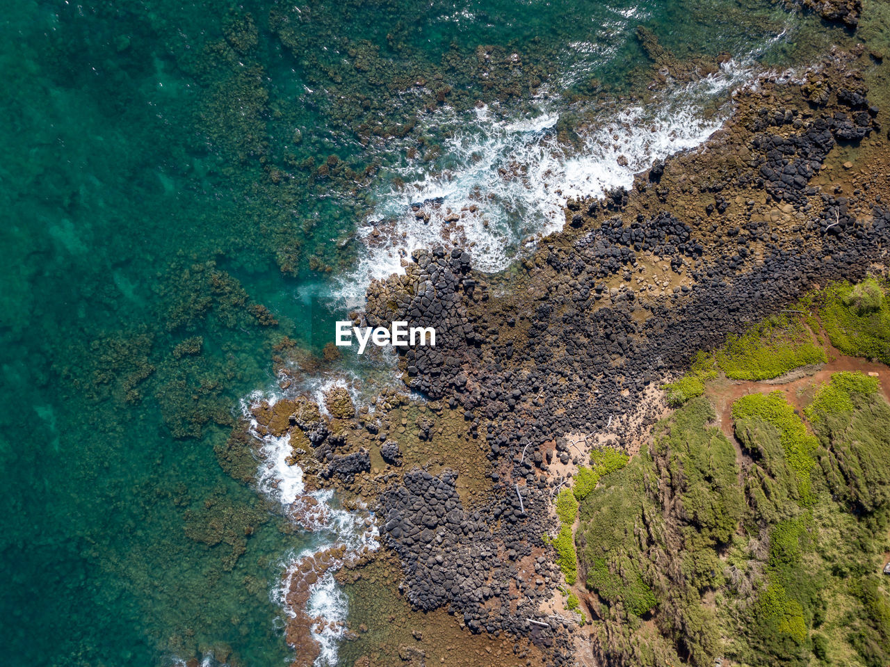HIGH ANGLE VIEW OF ROCKS ON SHORE AT SEA