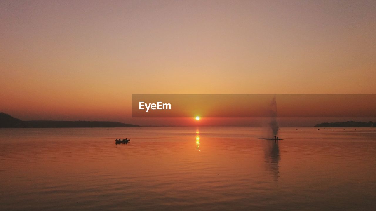 Scenic view of sea against orange sky